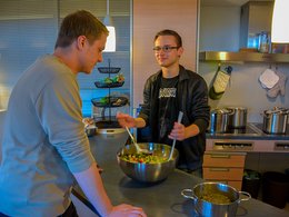 Zwei junge Männer kochen zusammen.