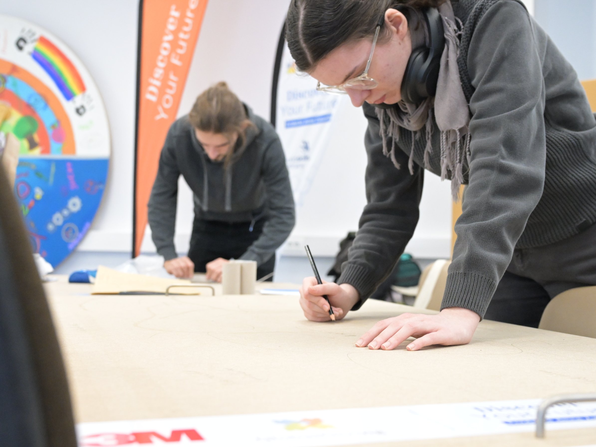 Zwei Personen schreiben etwas auf ein Plakat