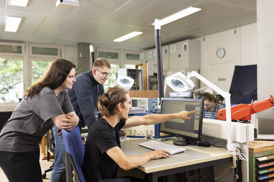 Drei Auszubildende arbeiten am Computer im Elektrobereich