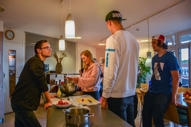 Vier Auszubildende kochen in der Küche des Internats
