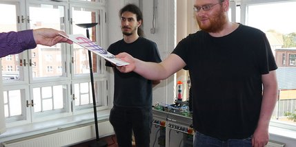 Zwei junge Männer erhalten eine Urkunde