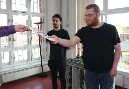 Zwei junge Männer erhalten eine Urkunde