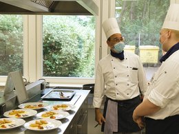 Zwei Köche neben angerichteten Speisen