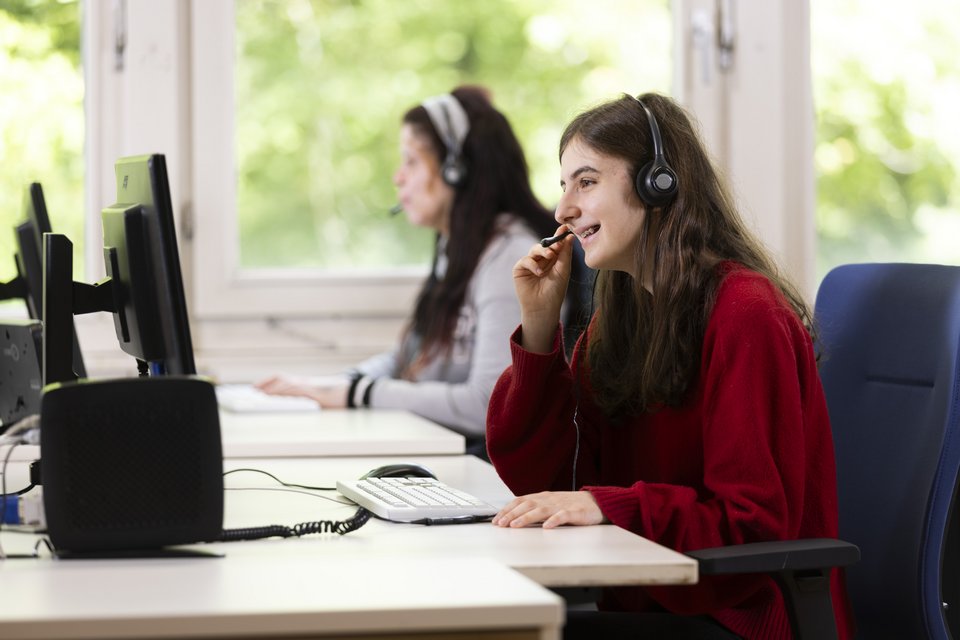 Zwei Auszubildende telefonieren mit Headsets