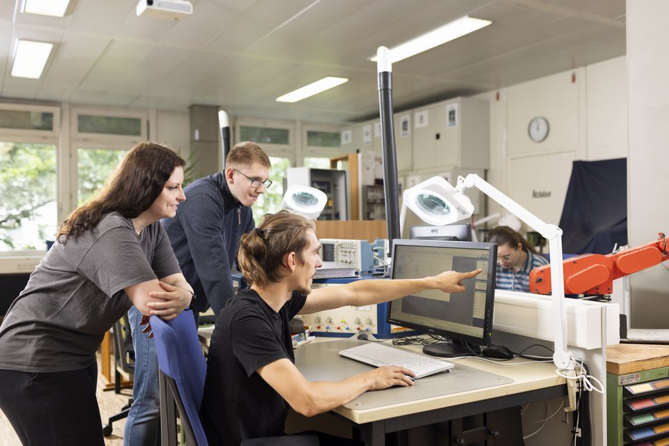 Drei Auszubildende arbeiten am Computer im Elektrobereich