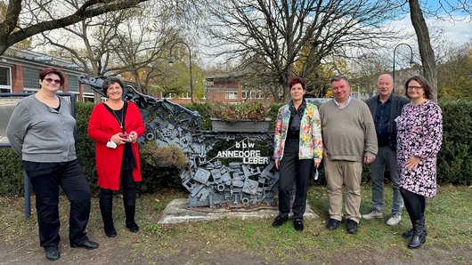 Mehrere Menschen stehen vor einer Skulptur mit dem Schriftzug "Annedore-Leber-BBW"
