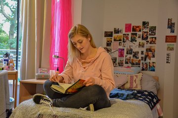 Auszubildende sitzt auf ihrem Bett im Internat