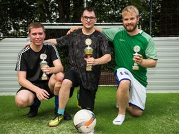 Drei junge Männer mit Pokalen