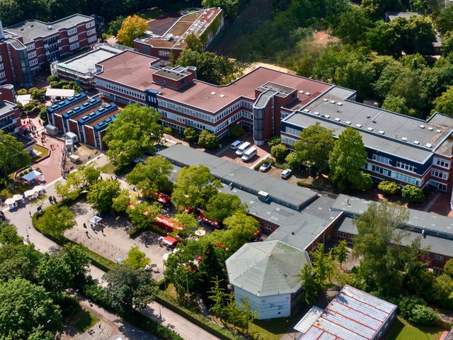Es sind mehrere Gebäude des ALBBW aus einer Luftaufnahme zu sehen. Es ist Sommer und die Bäume sind mit grünen Blättern bewachsen 