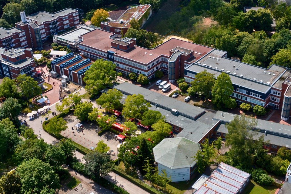 Es sind mehrere Gebäude des ALBBW aus einer Luftaufnahme zu sehen. Es ist Sommer und die Bäume sind mit grünen Blättern bewachsen 