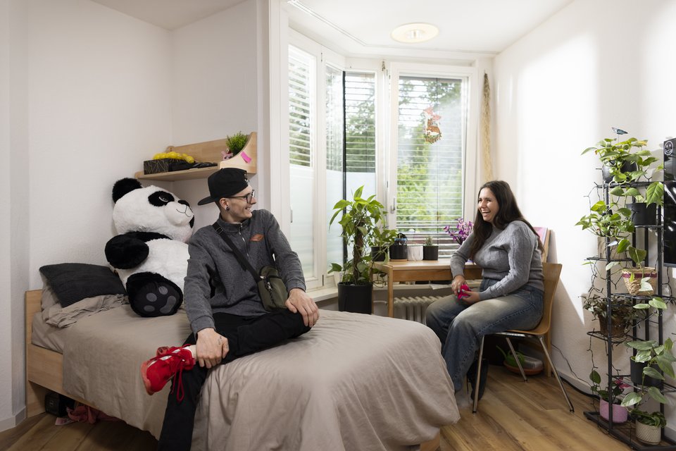 Ein Auszubildender besucht eine Auszubildende in ihrem Zimmer 