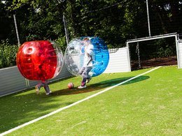 Zwei Menschen spielen Bubble Soccer.
