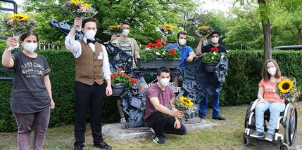 Die Preisträger, sieben junge Menschen, halten ihre Blumensträuße hoch.