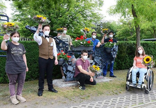 Die Preisträger, sieben junge Menschen, halten ihre Blumensträuße hoch.