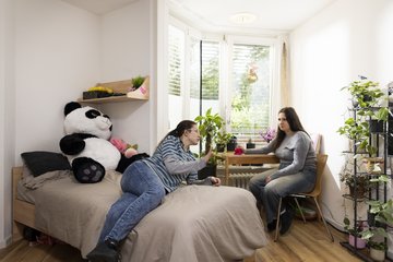 Eine Auszubildende besucht eine Auszubildende in ihrem Zimmer