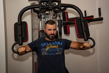 Auszubildender trainiert seine Arme am Fitnessgerät