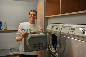 Auszubildender steht vor dem Trockner