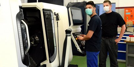 Zwei Männer an einer CNC-Maschine