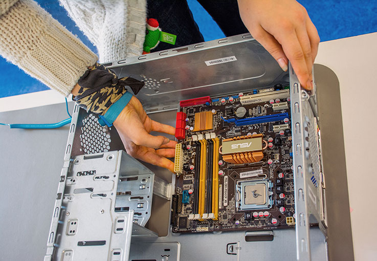 Detailaufnahme: Einsetzen von Komponenten in einen PC.
