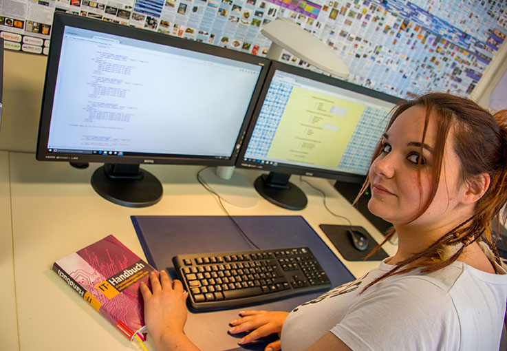 Eine junge Frau arbeitet an einem PC.