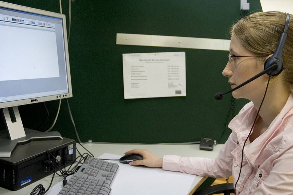 Frau mit Headset an einem PC