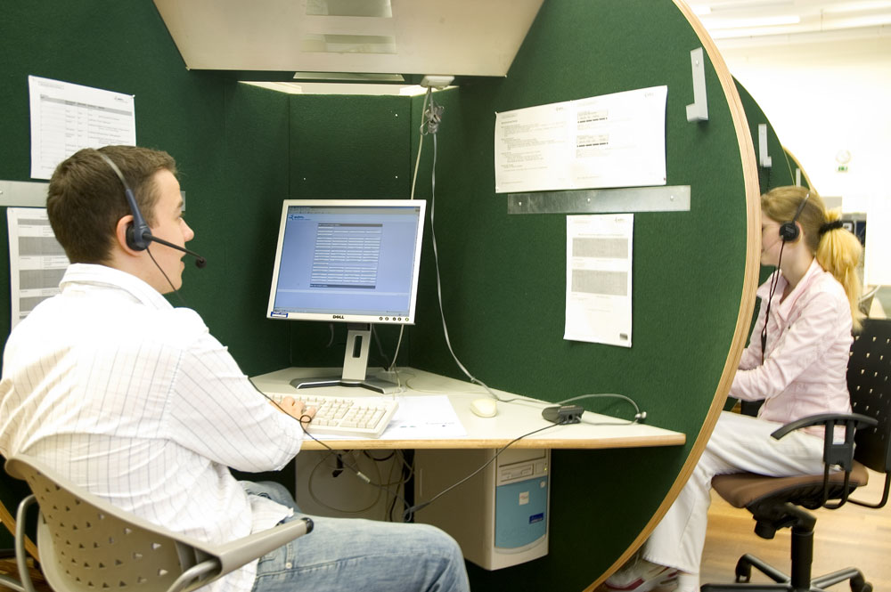 Zwei Menschen arbeiten mit Headsets in einem Callcenter.
