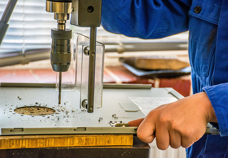 Jemand bohrt ein Loch in eine Metallplatte