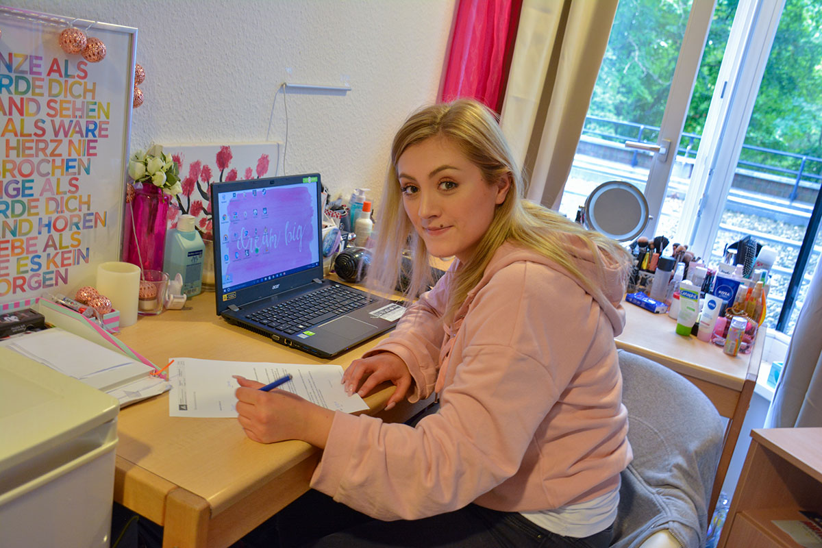 Auszubildende sitzt an ihrem Schreibtisch im Internat