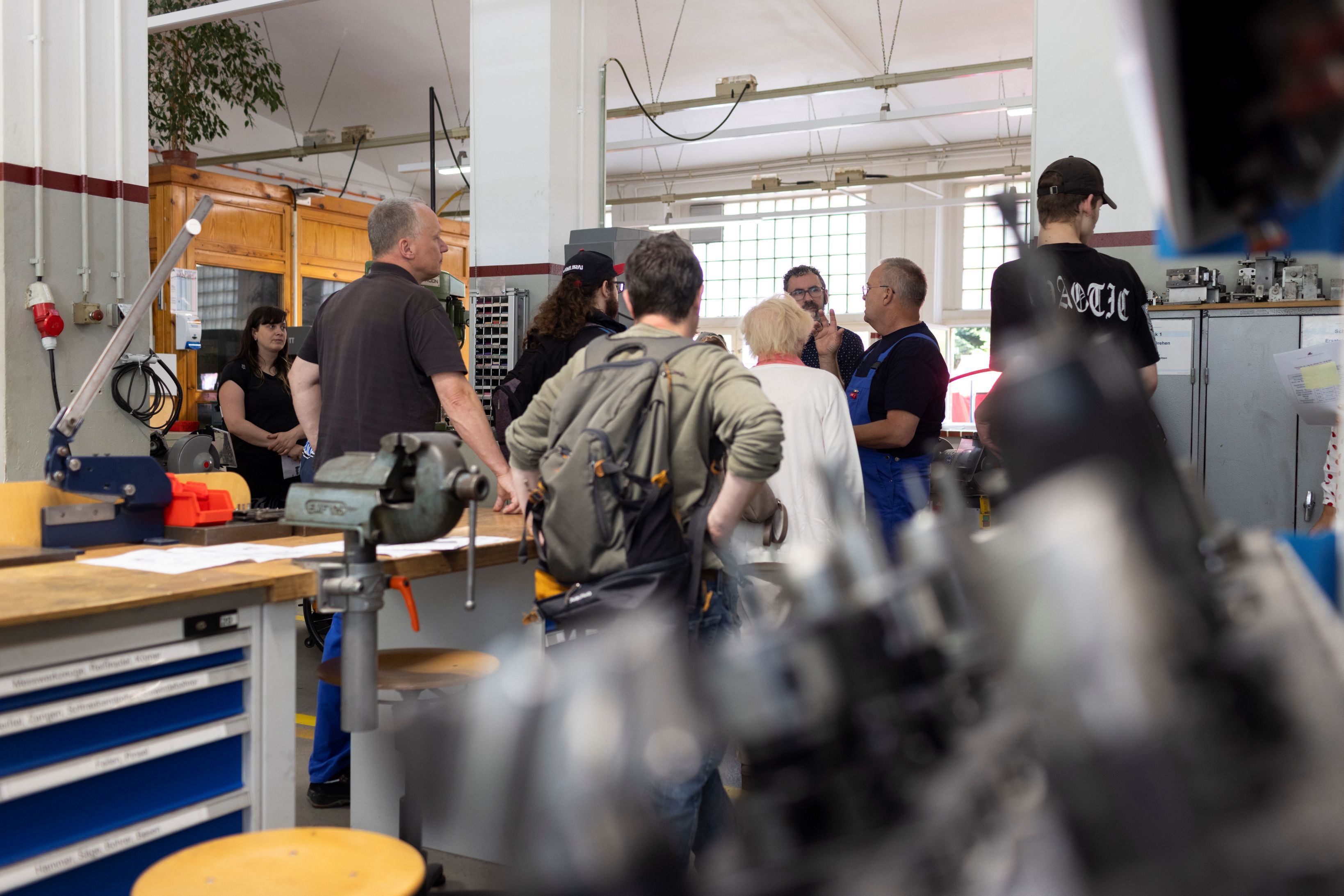 Menschen werden durch die Metallwerkstatt geführt